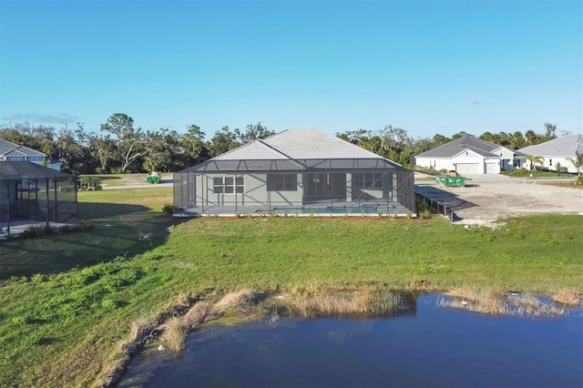 rear view of property with a yard, a water view, and a lanai