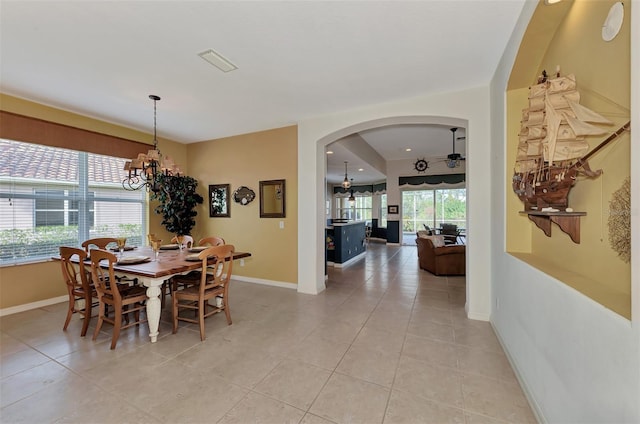 tiled dining room with a notable chandelier