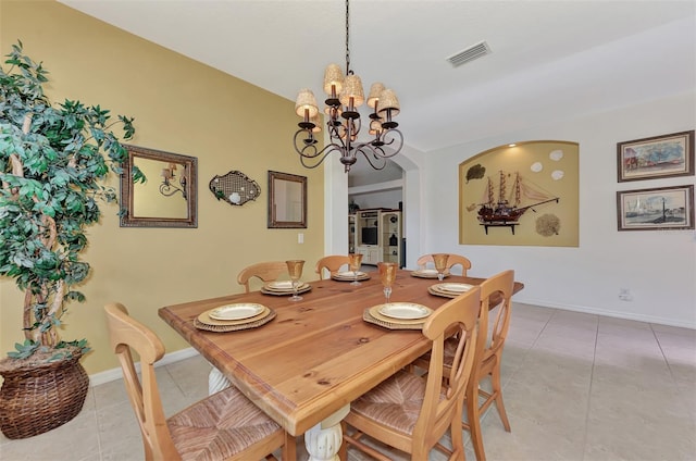 tiled dining room with an inviting chandelier