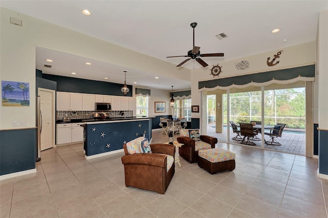 tiled living room with ceiling fan and a healthy amount of sunlight