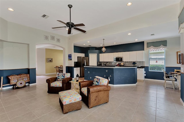 living room with light tile floors and ceiling fan