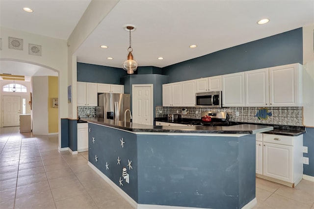 kitchen featuring decorative light fixtures, light tile flooring, appliances with stainless steel finishes, white cabinets, and tasteful backsplash