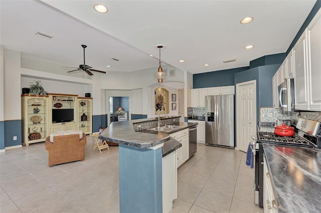 kitchen with white cabinetry, sink, stainless steel appliances, light tile floors, and pendant lighting