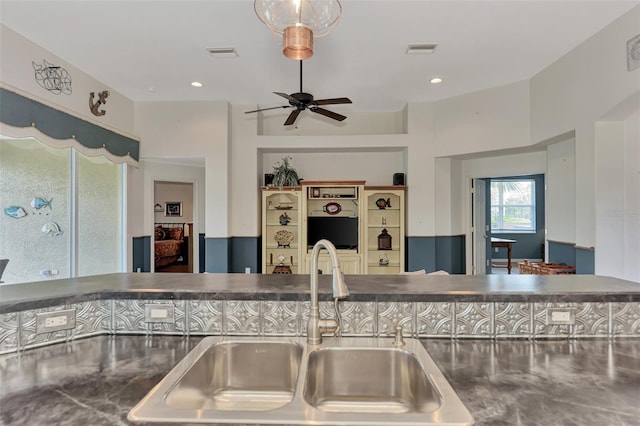 kitchen featuring stainless steel counters, ceiling fan, and sink