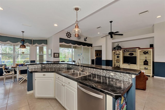 kitchen with a kitchen island with sink, sink, white cabinets, stainless steel dishwasher, and pendant lighting