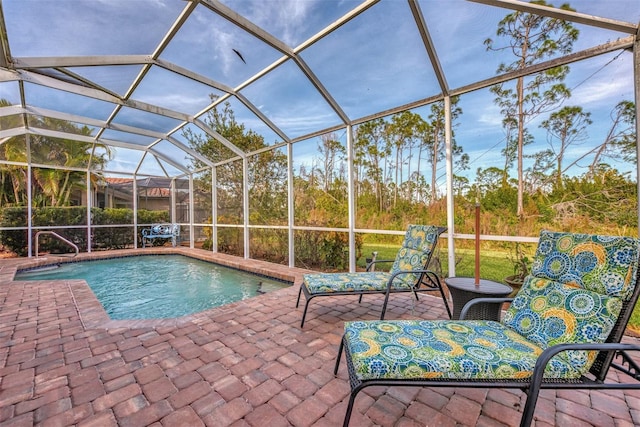 view of pool featuring glass enclosure and a patio