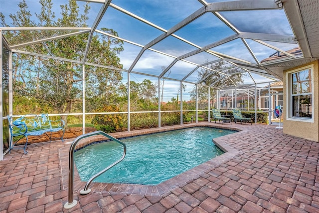 view of pool featuring glass enclosure and a patio