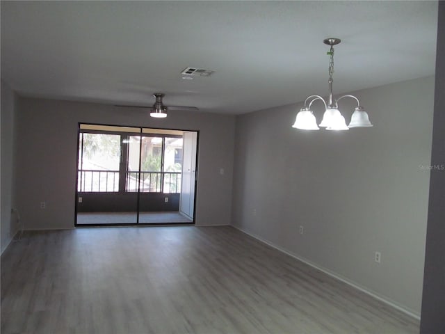 unfurnished room featuring wood-type flooring and ceiling fan with notable chandelier