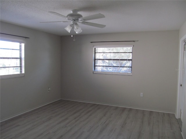 empty room with a textured ceiling, ceiling fan, and hardwood / wood-style flooring