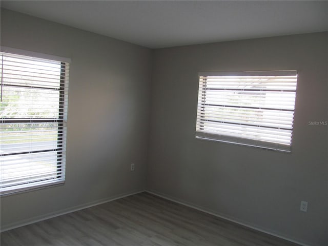 spare room with dark hardwood / wood-style floors and a wealth of natural light