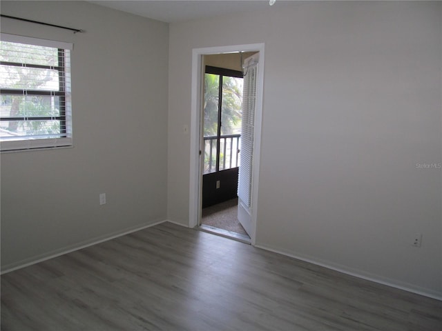 spare room featuring dark wood-type flooring and a wealth of natural light