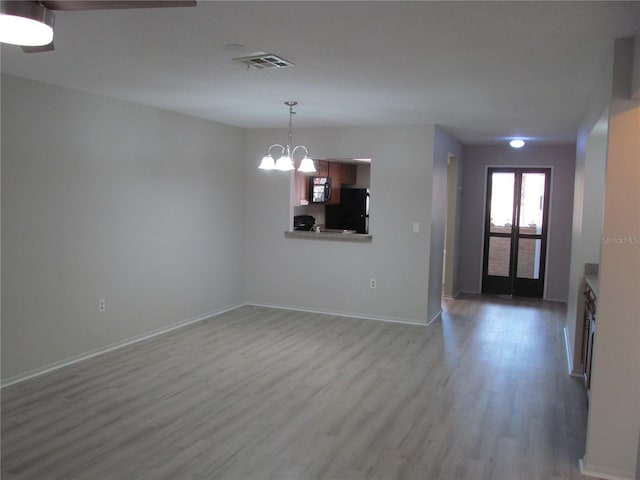 empty room featuring hardwood / wood-style floors and a chandelier