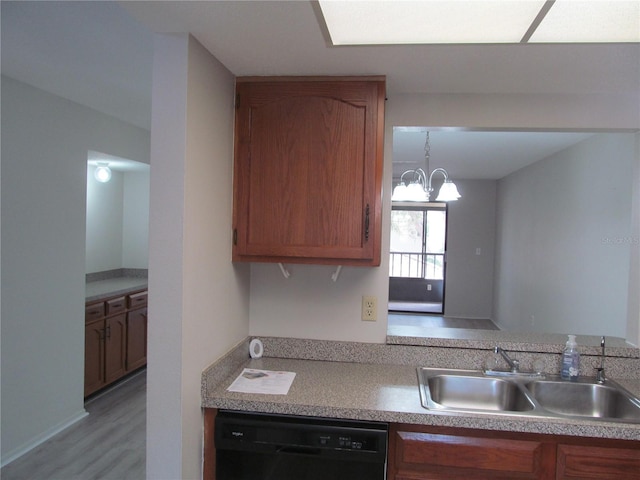 kitchen with sink, hanging light fixtures, dishwasher, light hardwood / wood-style floors, and an inviting chandelier