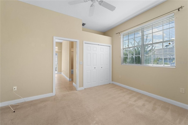 unfurnished bedroom featuring light colored carpet, a closet, and ceiling fan