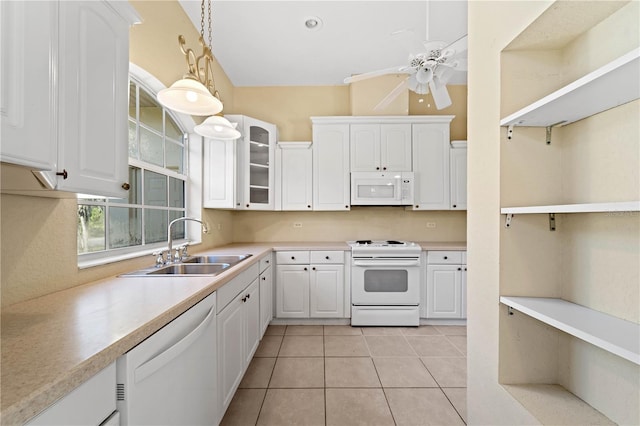 kitchen with white appliances, ceiling fan, sink, white cabinets, and light tile flooring