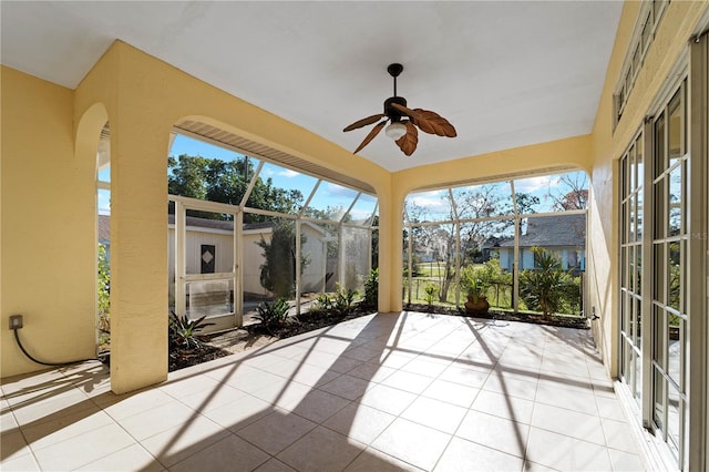 unfurnished sunroom with a healthy amount of sunlight and ceiling fan