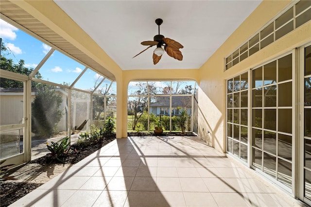 unfurnished sunroom with ceiling fan