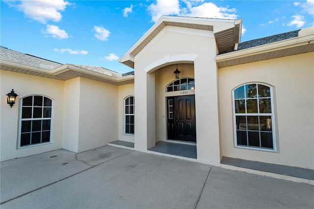 view of exterior entry with a patio area