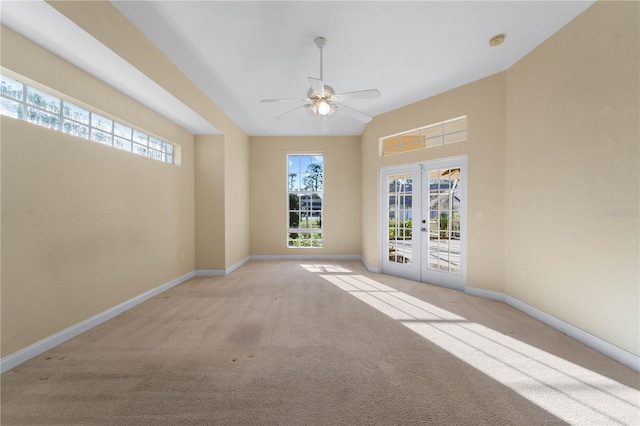 carpeted spare room featuring french doors and ceiling fan