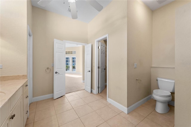 bathroom with tile floors, toilet, vanity, and ceiling fan