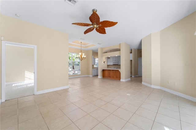 unfurnished living room featuring light tile flooring, a raised ceiling, and ceiling fan with notable chandelier