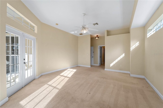 carpeted spare room with plenty of natural light, ceiling fan, and french doors