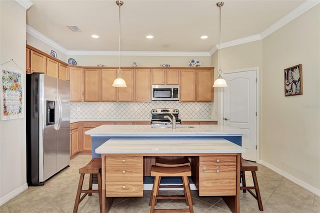 kitchen featuring stainless steel appliances, decorative light fixtures, tasteful backsplash, ornamental molding, and a center island with sink