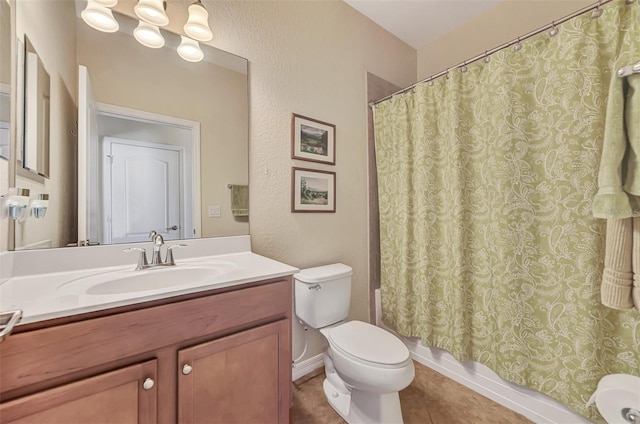 bathroom featuring toilet, tile floors, and vanity