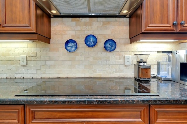 kitchen featuring dark stone counters, black electric stovetop, decorative backsplash, and range hood