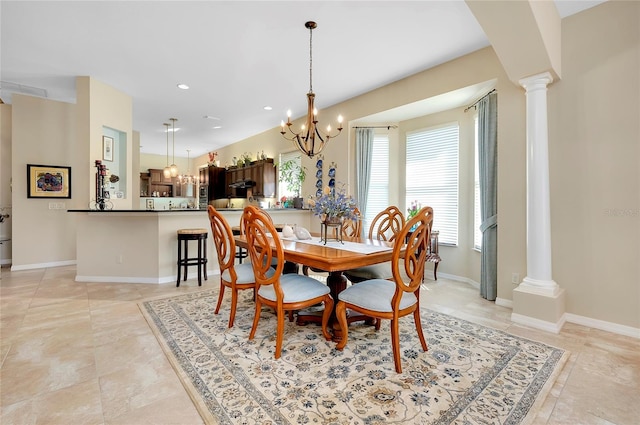 dining area with an inviting chandelier and decorative columns