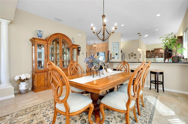 dining area featuring decorative columns and a notable chandelier