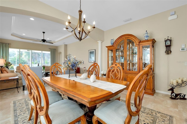 dining space featuring ceiling fan with notable chandelier and a tray ceiling