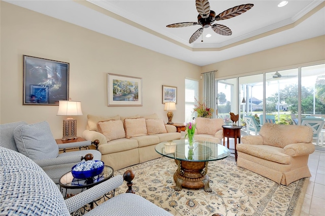 living room featuring ceiling fan, a raised ceiling, light tile patterned floors, and crown molding