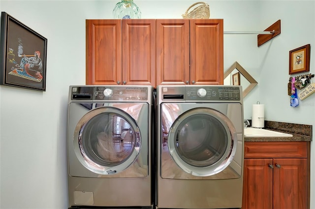 washroom featuring cabinets, sink, and washing machine and clothes dryer