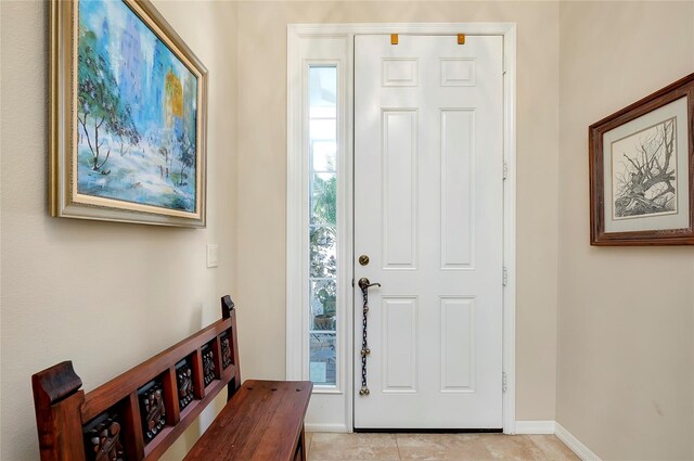 entryway with a wealth of natural light and light tile patterned floors