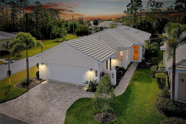 view of front facade with a yard and a garage