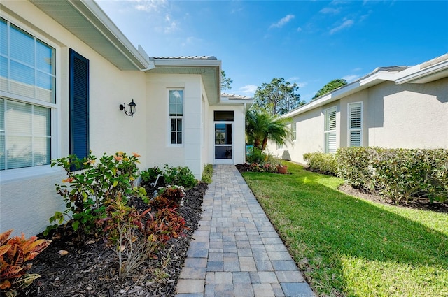 doorway to property featuring a lawn