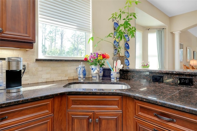 11065 Barnsley Dr, Venice, FL 34293 - kitchen featuring brown cabinets, a sink, backsplash, and a wealth of natural light