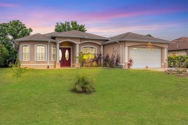 view of front facade with a garage and a yard