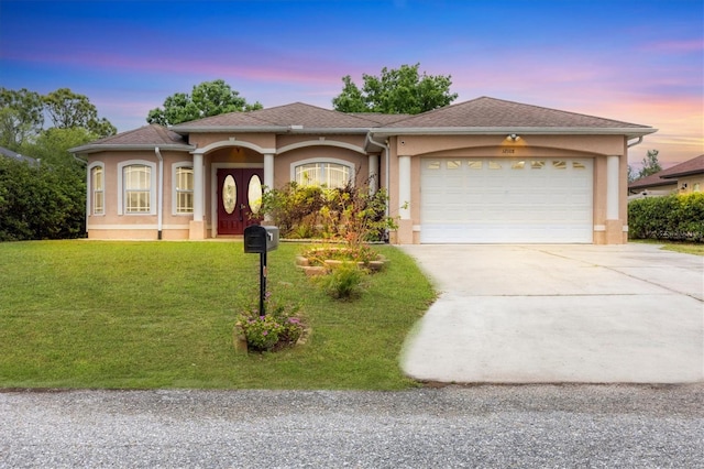 view of front of property featuring a yard and a garage