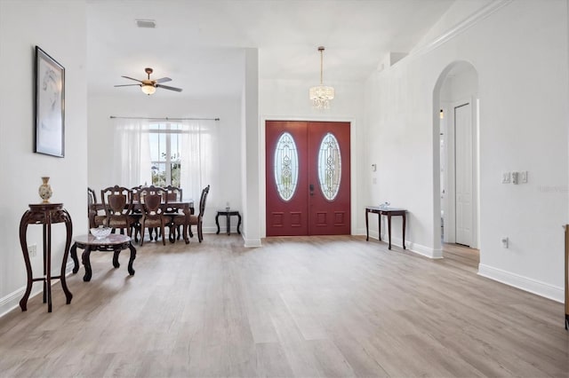 foyer entrance featuring ceiling fan with notable chandelier and light hardwood / wood-style flooring