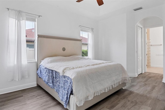 bedroom featuring ensuite bathroom, hardwood / wood-style floors, and ceiling fan