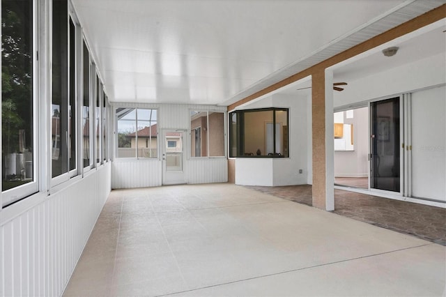 unfurnished sunroom with ceiling fan