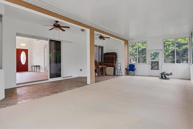 interior space featuring ceiling fan with notable chandelier