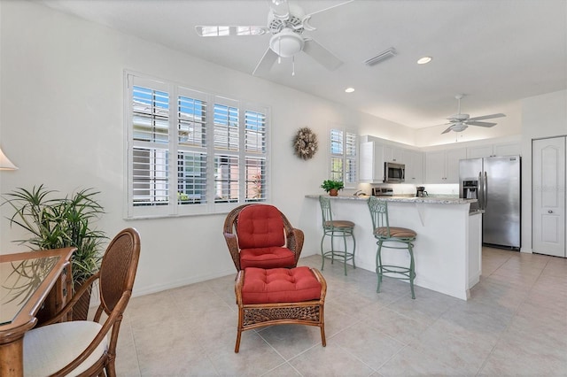 interior space with light tile floors, appliances with stainless steel finishes, white cabinetry, and ceiling fan