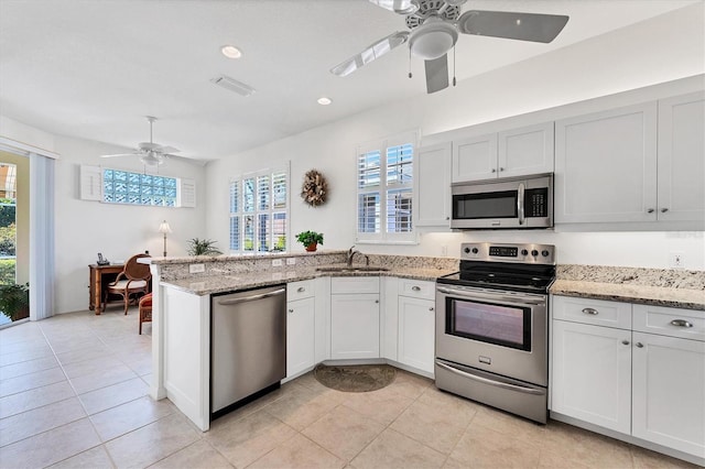 kitchen featuring light stone countertops, stainless steel appliances, ceiling fan, and white cabinetry