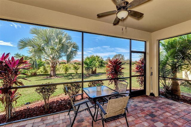 unfurnished sunroom with ceiling fan