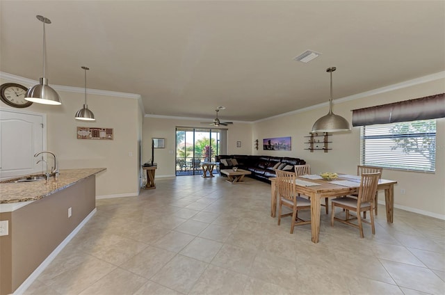 tiled dining area with ceiling fan, crown molding, and sink