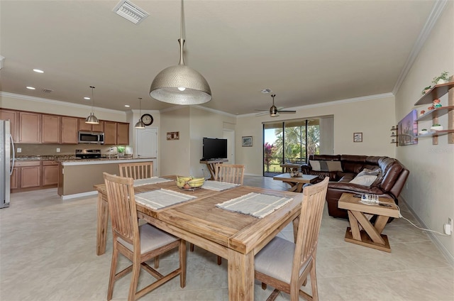 dining space featuring ceiling fan, sink, light tile patterned floors, and ornamental molding