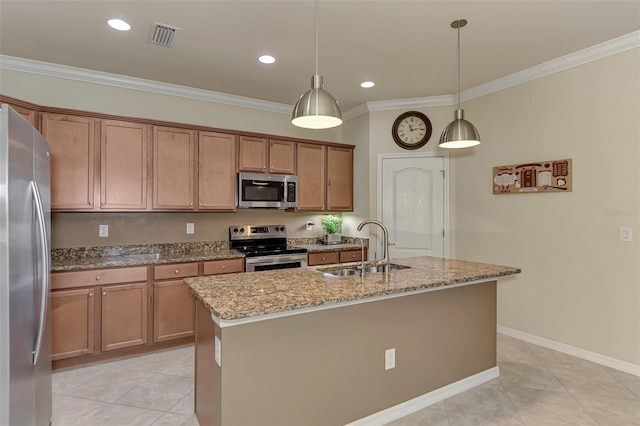 kitchen featuring pendant lighting, a center island with sink, sink, light stone counters, and stainless steel appliances